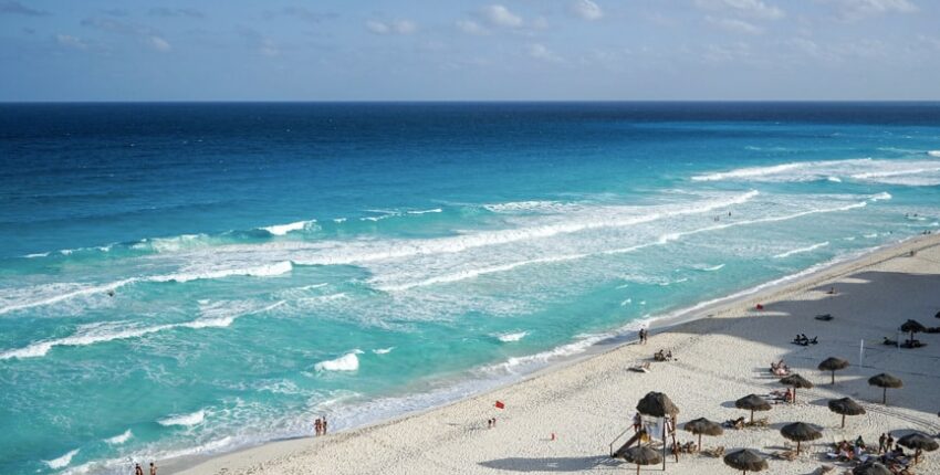 plage ensoleillée avec parasols et vagues turquoises