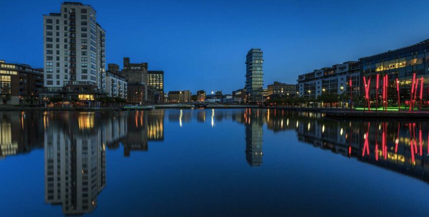 Paysage urbain au crépuscule reflété dans l'eau calme.