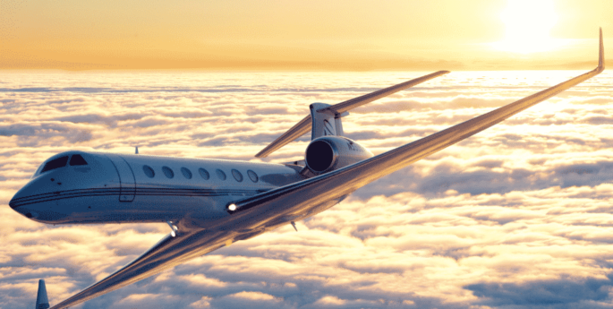 G550 jet privé en vol au dessus des nuages au couché de soleil