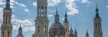 Saragosse : Basilique majestueuse sous un ciel partiellement nuageux.