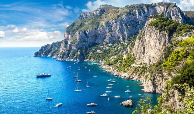 Capri entourée par des bateaux sur mer bleue.