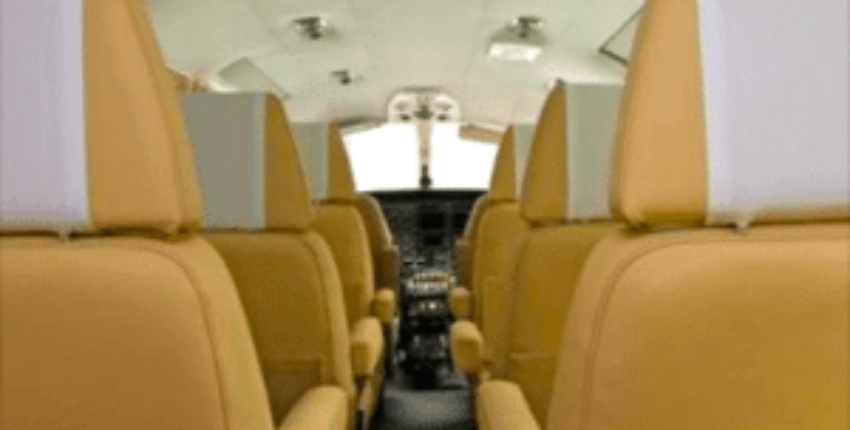 Emplacement de jet privé : cabine Cessna 406, sièges en cuir jaune.